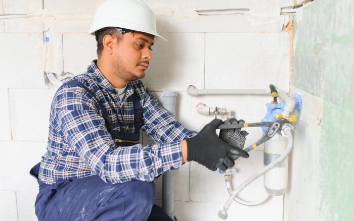 indian plumber installing water equipment meter filter pressure reducer
